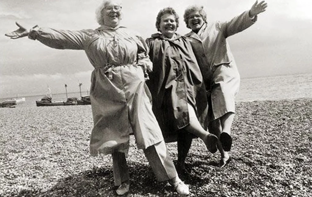 Femme senior joyeuse cueillant des plantes médicinales dans un champ